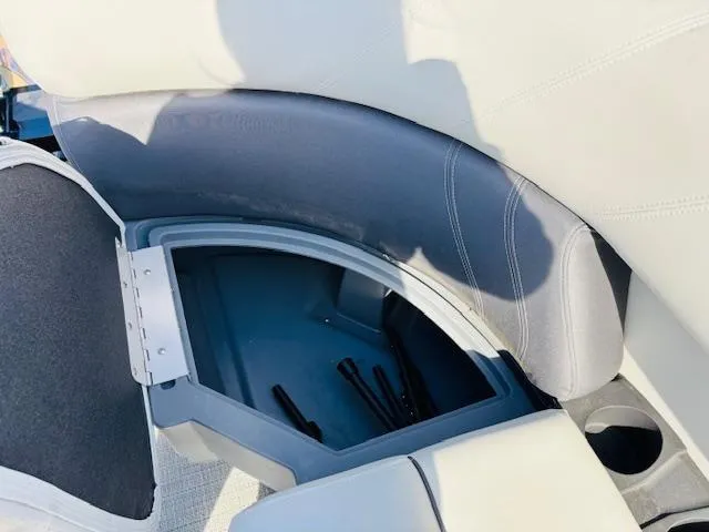 Slide: The Image of 2024 Sylvan Mirage 8522 LZ boat seat storage compartment, open with visible interior space. - 19