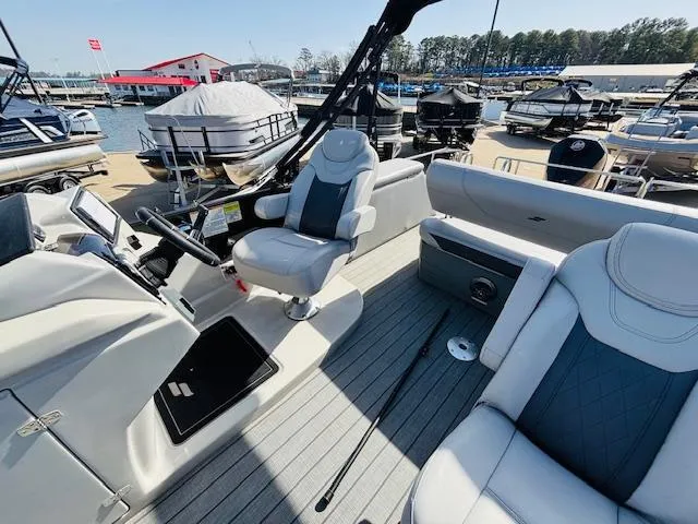 Slide: The Image of 2023 Starcraft SLS-5 Q DH boat interior with modern seating and control panel at marina. - 13
