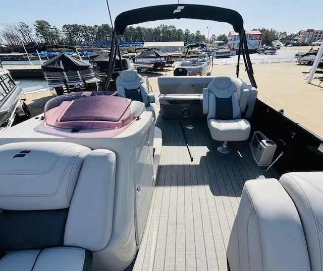 Slide: The Image of 2023 Starcraft SLS-5 Q DH boat interior with plush seating at a marina. - 6