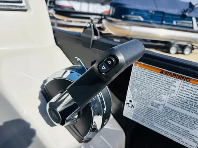 Slide: The Image of Throttle control of 2023 Starcraft SLS-5 Q DH boat, with warning label and background boats. - 9