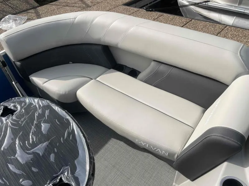 Slide: The Image of 2024 Sylvan MIRAGE 822 CLZ DH boat interior with gray seating and table. - 9