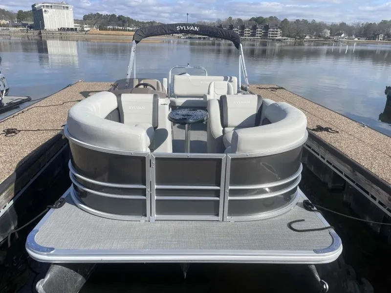 Slide: The Image of 2024 Sylvan MIRAGE 822 CLZ DH pontoon boat docked on a calm lake. - 2