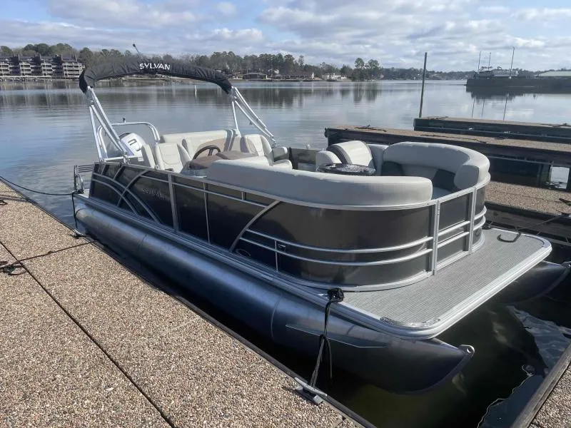 Slide: The Image of 2024 Sylvan MIRAGE 822 CLZ DH pontoon boat docked on a calm lake. - 3