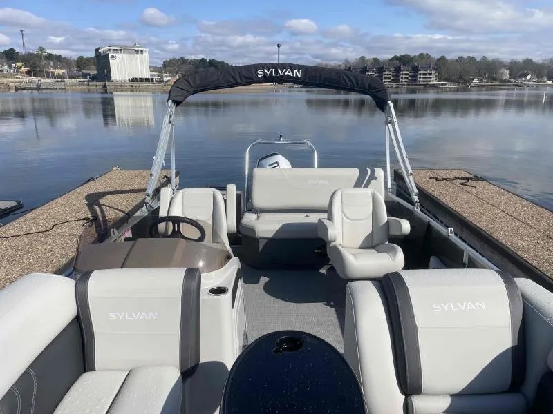 Slide: The Image of 2024 Sylvan MIRAGE 822 CLZ DH pontoon boat interior at a dock, with seating and steering console. - 7