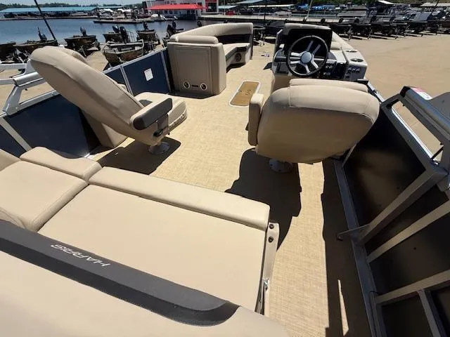 Slide: The Image of 2024 Harris HCX 25 Cruiser 250 boat interior with beige seating and steering console. - 14