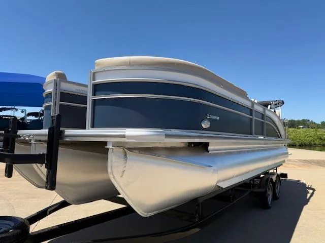 Slide: The Image of 2024 Harris HCX 25 Cruiser 250 pontoon boat on trailer, under clear blue sky. - 3
