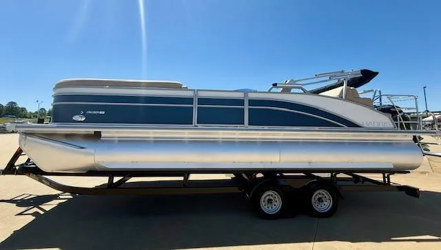 Slide: The Image of 2024 Harris Boats HCX 25 Cruiser 250 pontoon on trailer, under clear blue sky. - 4