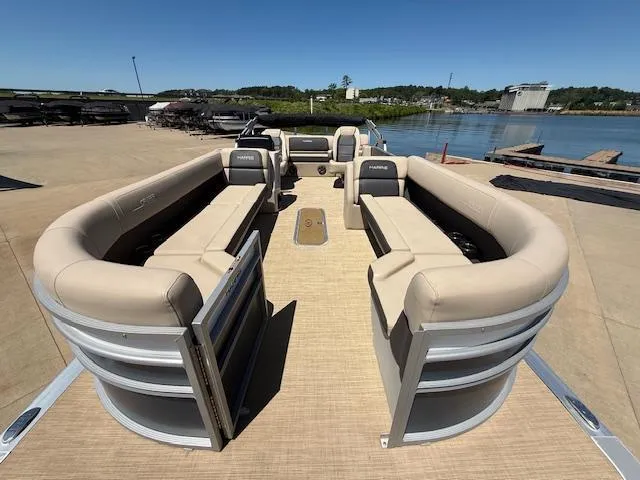 Slide: The Image of 2024 Harris Boats HCX 25 Cruiser 250 pontoon with spacious seating, docked by a serene waterfront. - 9