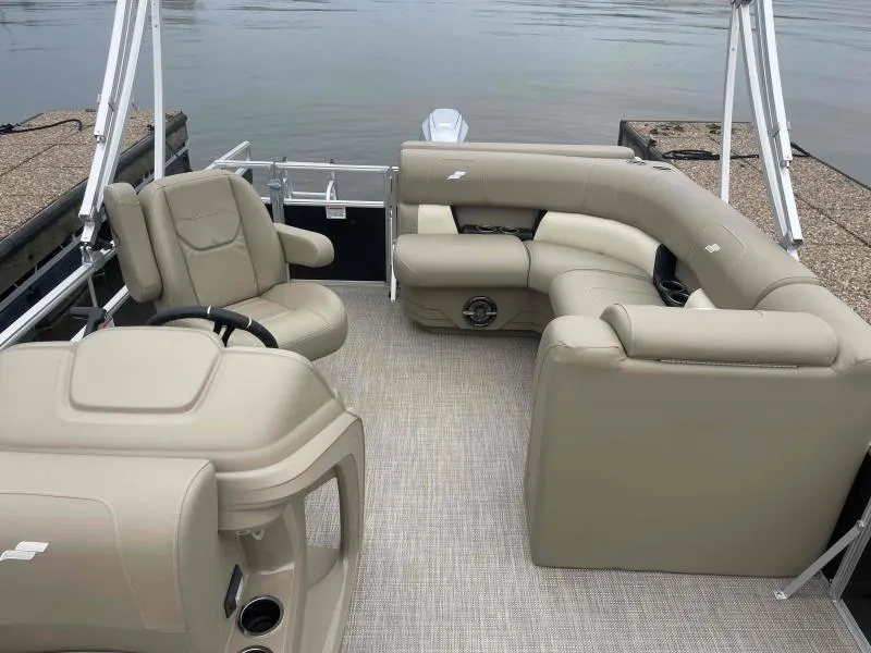 Slide: The Image of 2024 Starcraft LX 20 CB pontoon boat interior with beige seating and steering console. - 11