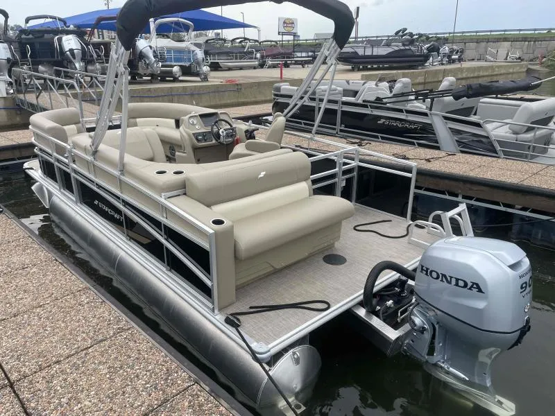 Slide: The Image of 2024 Starcraft LX 20 CB pontoon boat with Honda outboard motor docked at marina. - 4