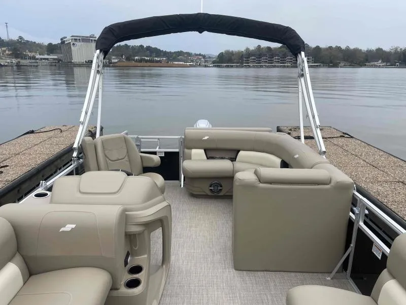 Slide: The Image of 2024 Starcraft LX 20 CB pontoon boat with beige seating on a calm lake. - 6