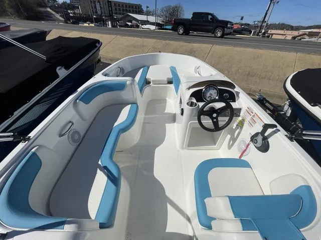 Slide: The Image of 2023 Bayliner E18 boat interior with blue and white seating, steering wheel, and dashboard. - 5