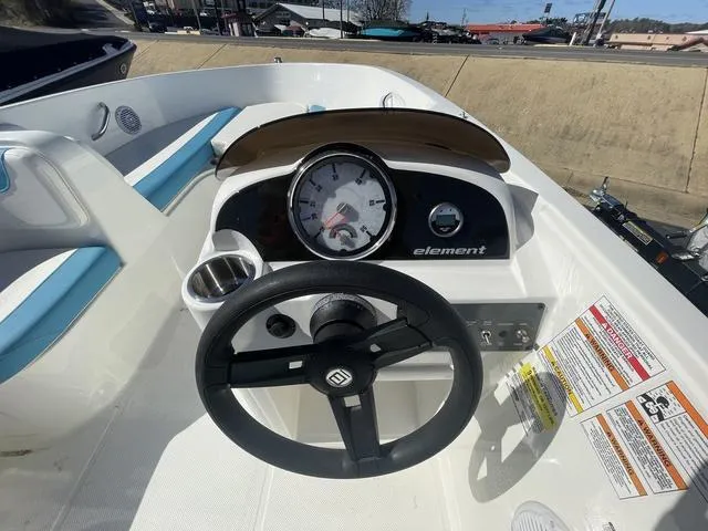 Slide: The Image of 2023 Bayliner E18 boat dashboard with steering wheel and gauges. - 6
