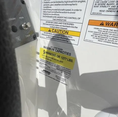 Slide: The Image of 2023 Bayliner E18 boat capacity label, maximum 9 persons or 1277 lbs. - 9