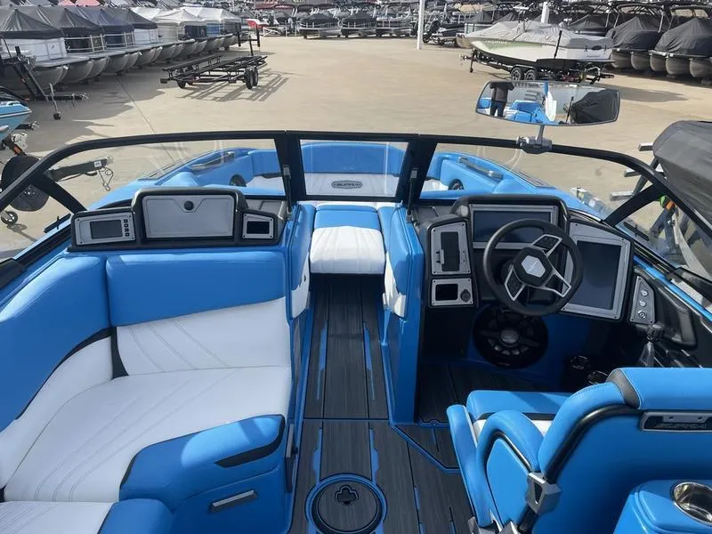 Slide: The Image of 2023 Supra SUPRA SA 450 boat interior with blue and white seating, modern dashboard, and steering wheel. - 14