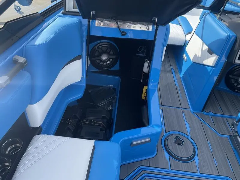 Slide: The Image of 2023 Supra SA 450 interior with blue and white seating, speaker system, and storage compartment. - 18