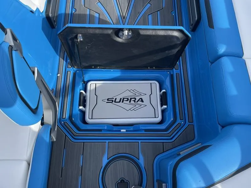 Slide: The Image of 2023 Supra SA 450 boat interior with blue seating and storage compartment. - 20