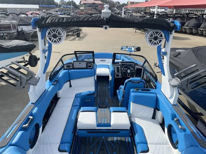 Slide: The Image of 2023 Supra SUPRA SA 450 boat interior with blue and white seating, advanced dashboard, and speakers. - 21