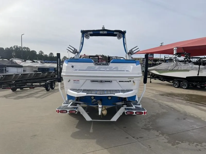 Slide: The Image of 2023 Supra SUPRA SA 450 boat displayed at a marina, rear view. - 7