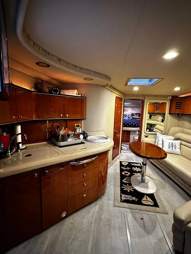 Slide: The Image of Luxurious interior of 2000 Sea Ray 460 Sundancer yacht with modern kitchen and seating area. - 11