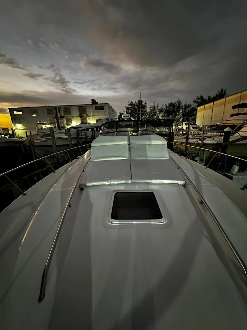 Slide: The Image of 2000 Sea Ray 460 Sundancer yacht at dusk, docked with a scenic backdrop. - 16