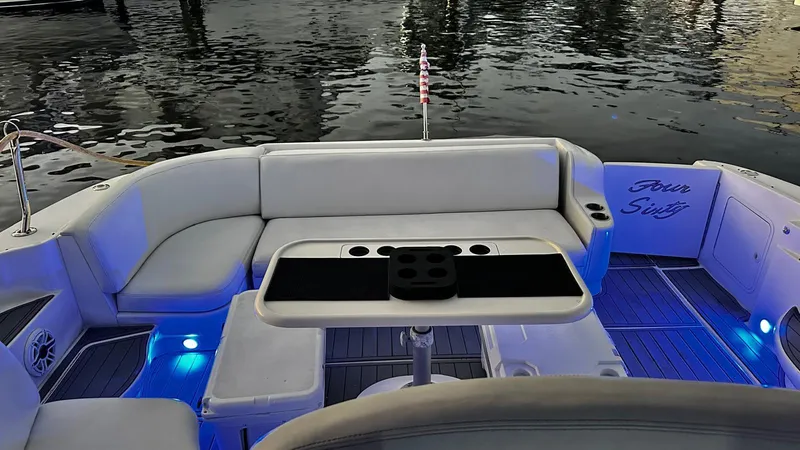 Slide: The Image of Sea Ray 460 Sundancer 2000 boat interior with seating and table, ambient blue lighting. - 4