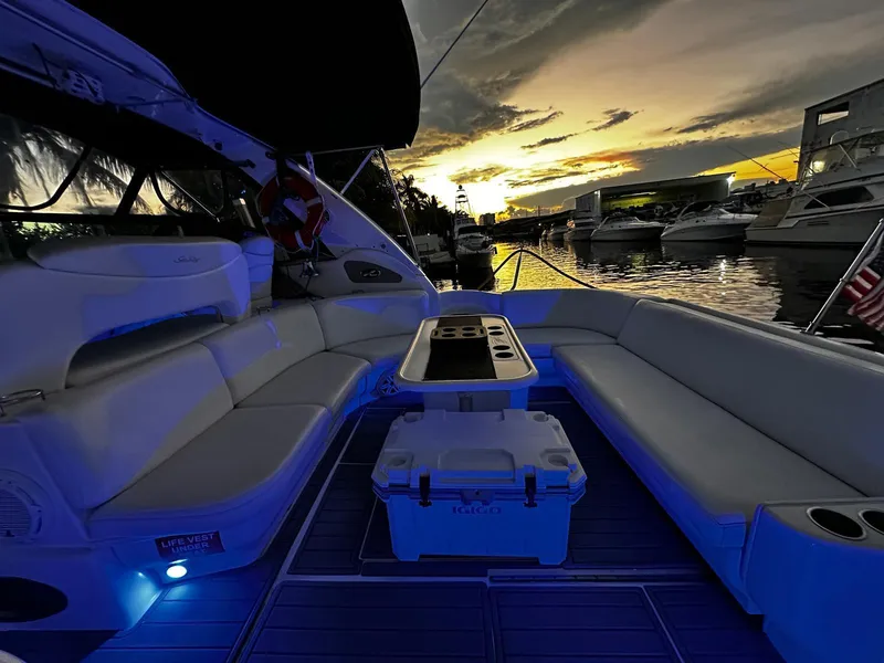 Slide: The Image of Sea Ray 460 Sundancer 2000 yacht interior at sunset, featuring elegant seating and ambient lighting. - 5