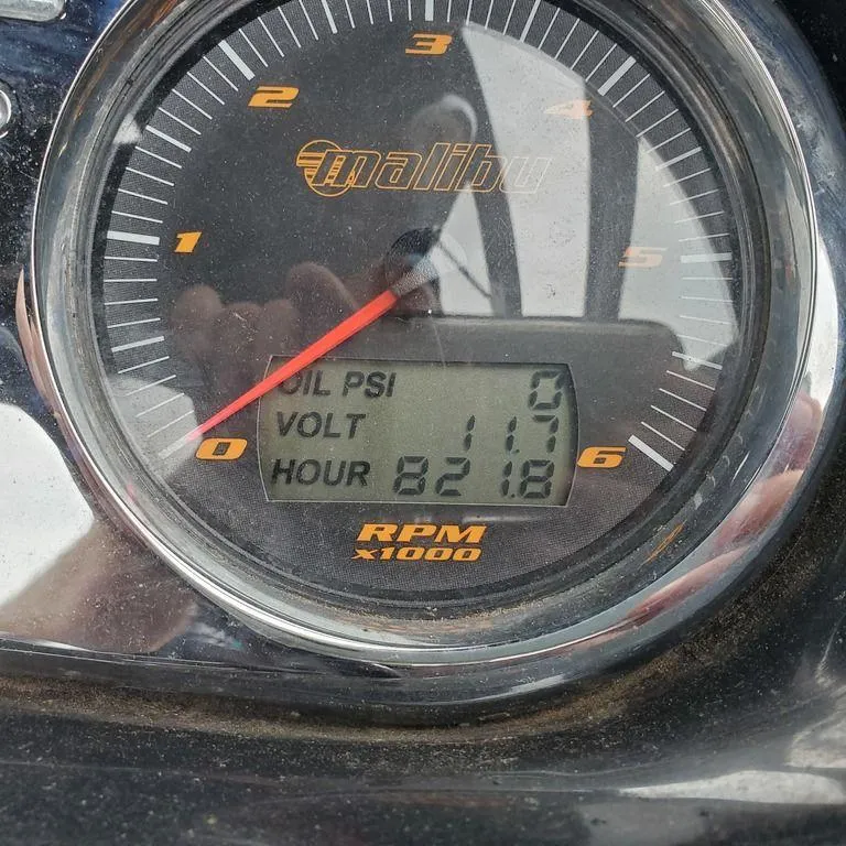 Slide: The Image of Close-up of 2006 Malibu 23 LSV gauge displaying oil PSI, voltage, and hours. - 12