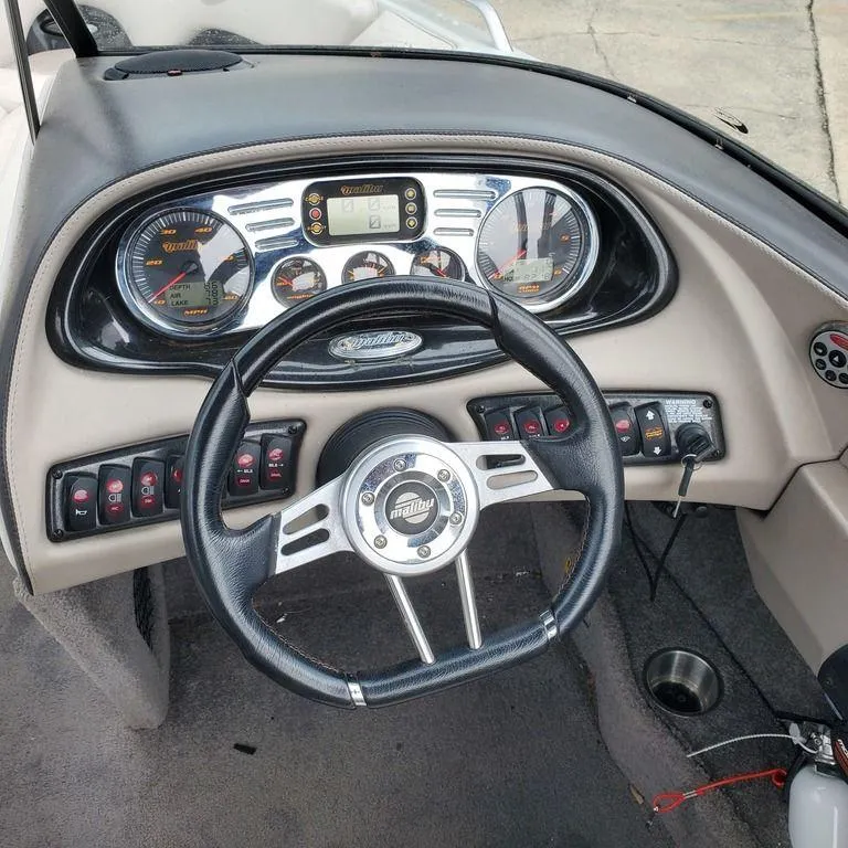 Slide: The Image of Dashboard of a 2006 Malibu 23 LSV boat with steering wheel and gauges. - 4