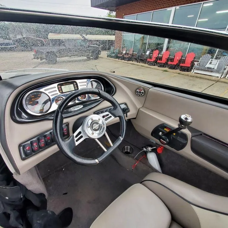 Slide: The Image of Interior of a 2006 Malibu 23 LSV boat with steering wheel and dashboard controls. - 6