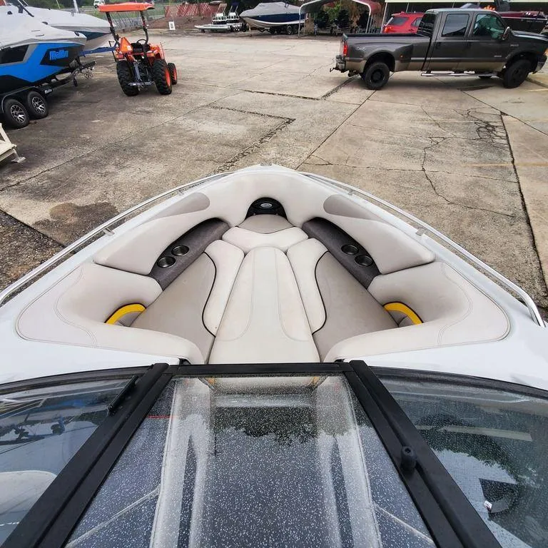 Slide: The Image of 2006 Malibu 23 LSV boat interior with white cushioned seating and outdoor setting. - 9