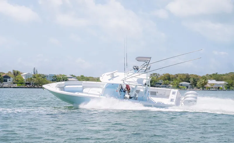 Slide: The Image of 2022 Contender 44ST boat speeding on water, showcasing sleek design and powerful engines. - 10