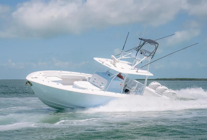 Slide: The Image of 2022 Contender 44ST boat speeding on open water under clear skies. - 11