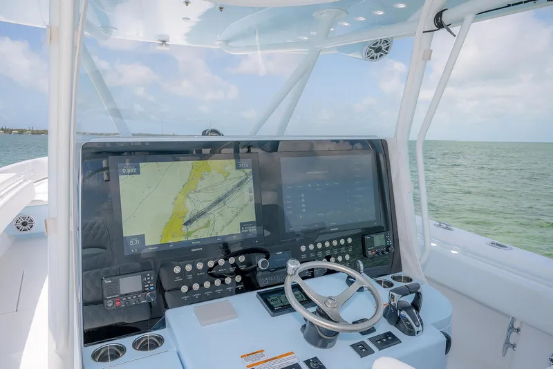 Slide: The Image of 2022 Contender 44ST boat dashboard with navigation screens and steering wheel. - 22