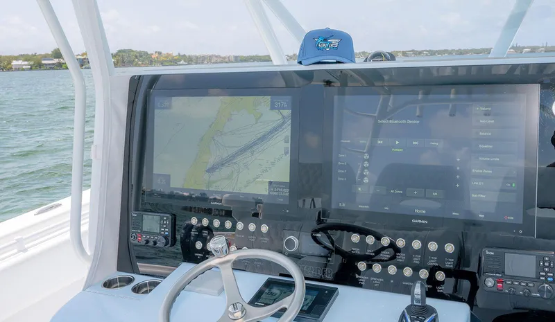 Slide: The Image of Contender 44ST 2022 boat dashboard with navigation screens and steering wheel. - 23