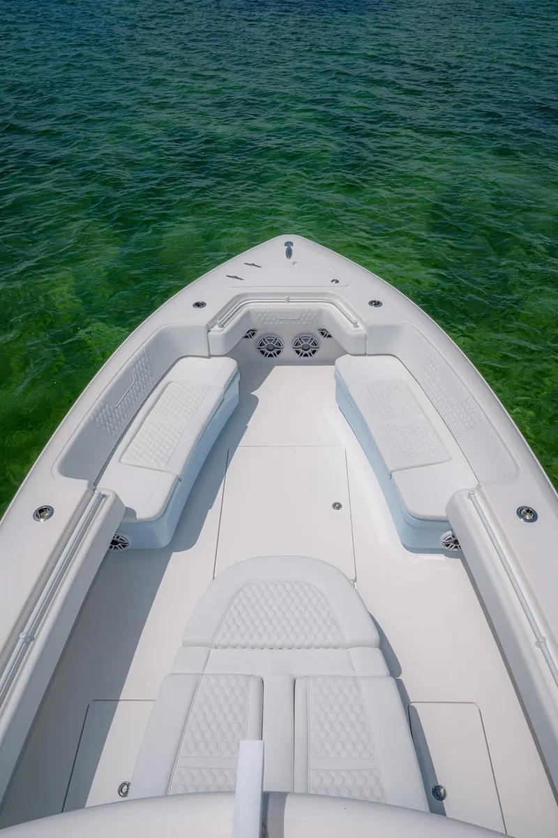 Slide: The Image of 2022 Contender 44ST boat with white seating, floating on clear green water. - 24