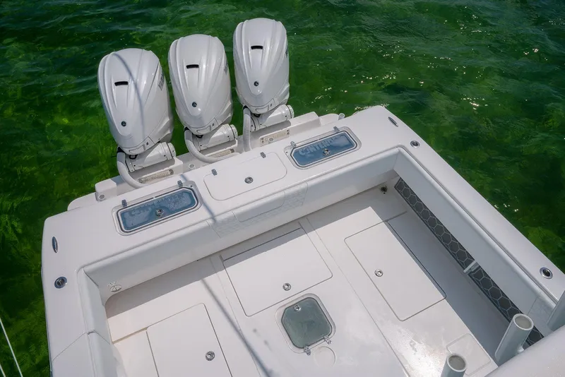 Slide: The Image of 2022 Contender 44ST boat with triple outboard engines on clear green water. - 26