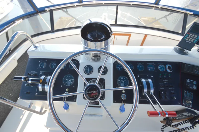 Slide: The Image of 1991 Carver 43 Cockpit Motoryacht helm with steering wheel and control panel. - 12