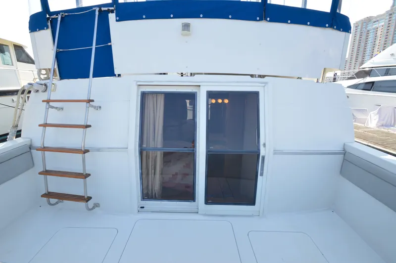 Slide: The Image of 1991 Carver 43 Cockpit Motoryacht with blue canopy and wooden ladder. - 17