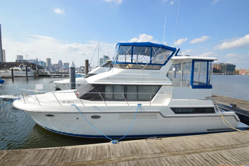 Slide: The Image of 1991 Carver 43 Cockpit Motoryacht docked in a marina under a clear sky. - 24