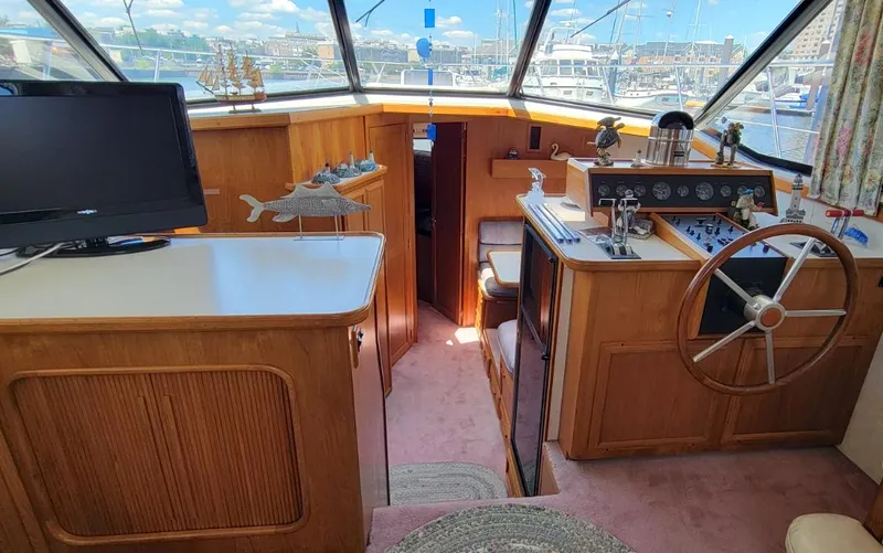 Slide: The Image of Interior of 1991 Carver 43 Cockpit Motoryacht with helm, steering wheel, and TV. - 33