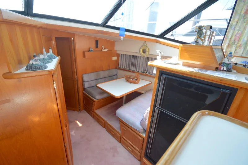 Slide: The Image of Interior of 1991 Carver 43 Cockpit Motoryacht with cozy dining area and wooden cabinetry. - 36