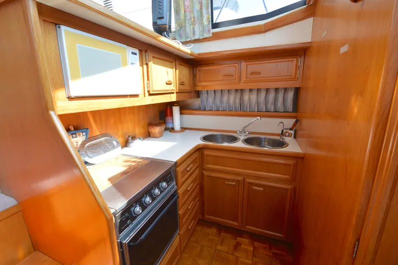 Slide: The Image of 1991 Carver 43 Cockpit Motoryacht kitchen with wood cabinetry and dual sinks. - 37