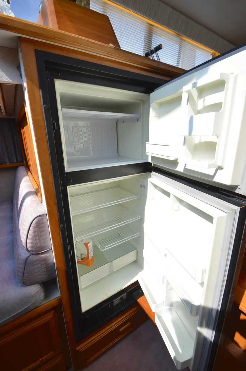 Slide: The Image of Open refrigerator inside 1991 Carver 43 Cockpit Motoryacht, showcasing interior storage space. - 39
