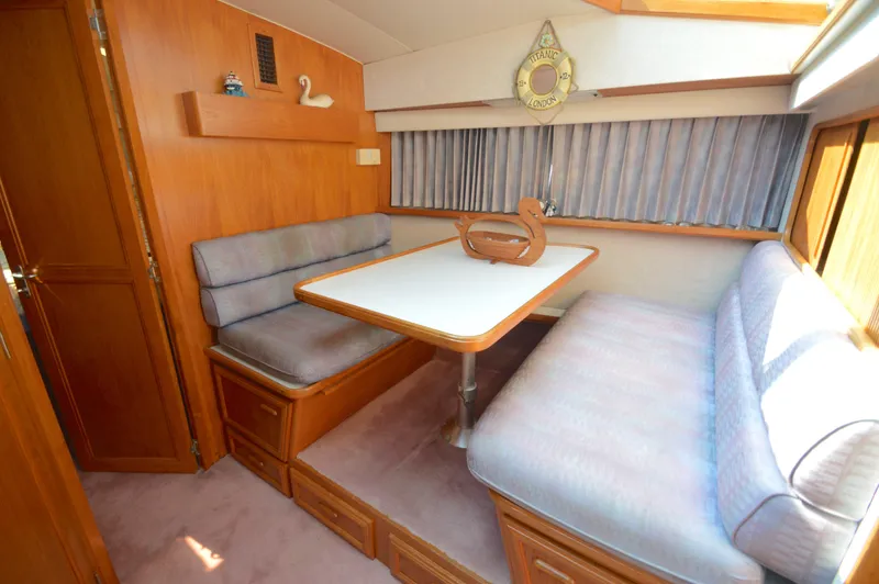 Slide: The Image of 1991 Carver 43 Cockpit Motoryacht interior with cozy dining area and wooden accents. - 42