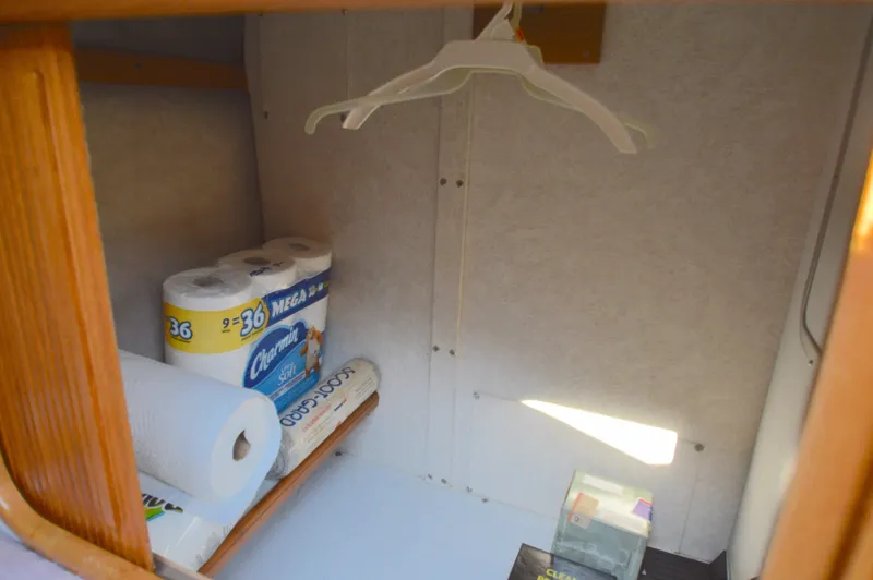 Slide: The Image of Storage area in 1991 Carver 43 Cockpit Motoryacht with paper towels and hangers. - 44