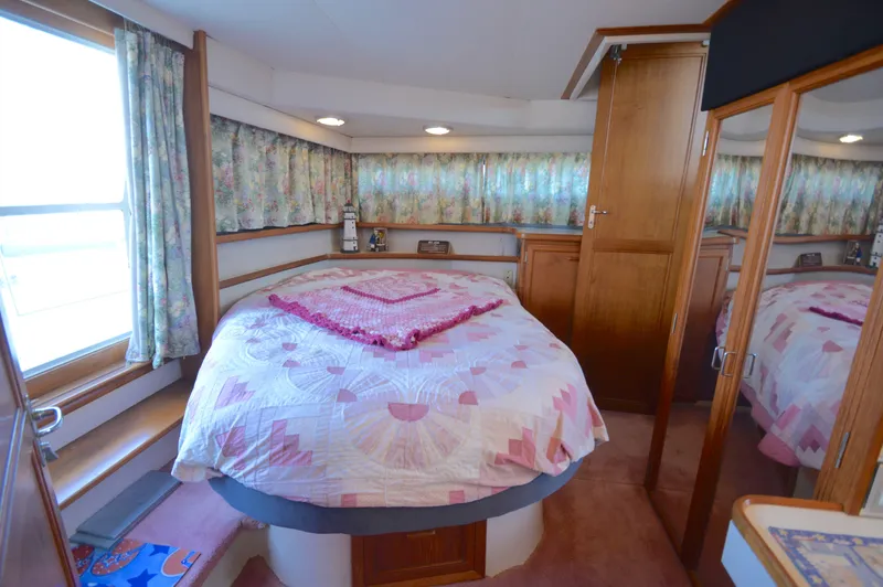 Slide: The Image of Cozy bedroom in 1991 Carver 43 Cockpit Motoryacht with floral decor and quilted bedspread. - 48