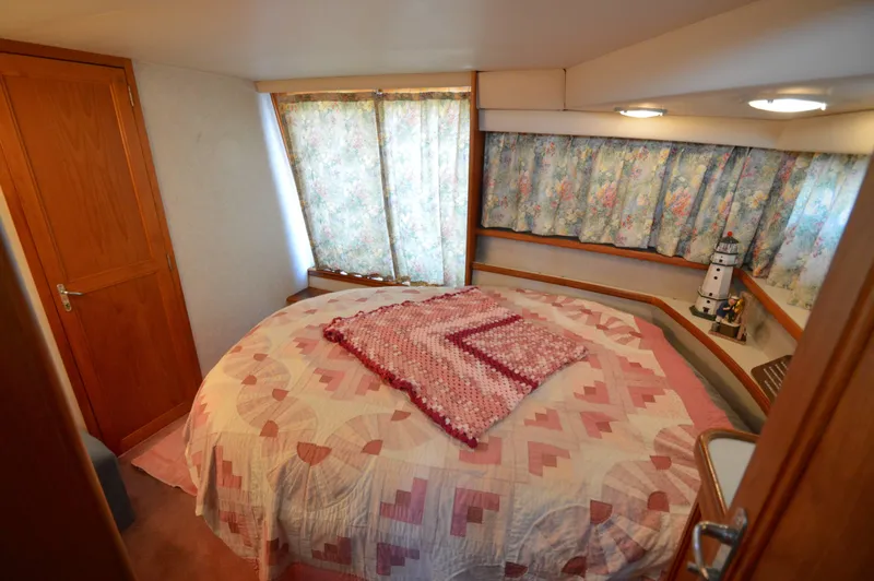 Slide: The Image of Cozy bedroom in 1991 Carver 43 Cockpit Motoryacht with floral curtains and quilted bedspread. - 49