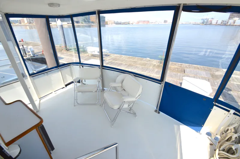 Slide: The Image of 1991 Carver 43 Cockpit Motoryacht interior with waterfront view and seating area. - 6