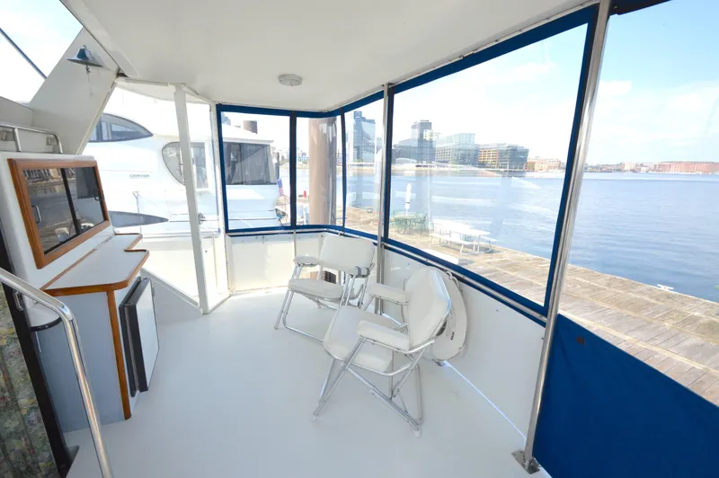 Slide: The Image of 1991 Carver 43 Cockpit Motoryacht interior with waterfront view and seating area. - 7